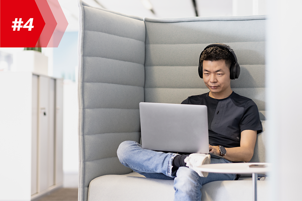Henkel-ansatt Hao, leder for Mobile App Factory, med hodetelefoner og bærbar PC
