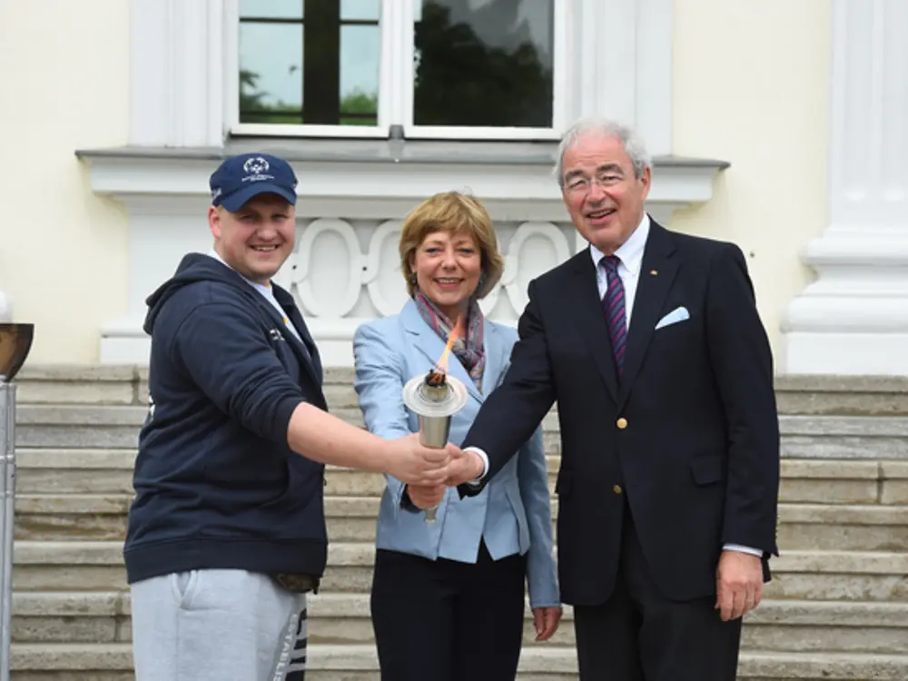 Dennis Mellentin, Athletensprecher von SOD Berlin/Brandenburg, SOD-Schirmherrin Daniela Schadt und SOD-Präsident Gernot Mittler (von links) entzündeten die Fackel vor dem Schloss Bellevue. 